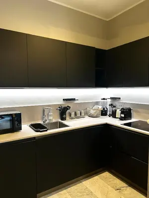 a kitchen with black cabinets and a sink at Via Veneto Luxury Maison in Rome