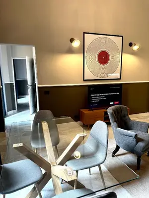 a living room with chairs and a table and a tv at Via Veneto Luxury Maison in Rome