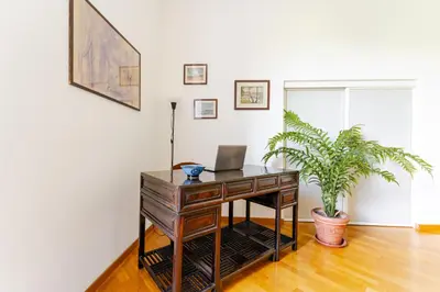 an office with a desk with a laptop and a plant at Trastevere - Dolce Vita 4bedr 360 Terrace in Rome