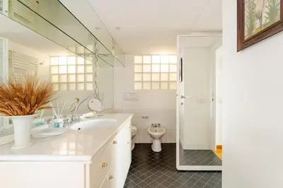 a white bathroom with a sink and a toilet at Trastevere - Dolce Vita 4bedr 360 Terrace in Rome