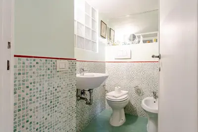 a bathroom with a toilet and a sink at Trastevere - Dolce Vita 4bedr 360 Terrace in Rome