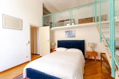 a bedroom with a blue bed and a staircase at Trastevere - Dolce Vita 4bedr 360 Terrace in Rome