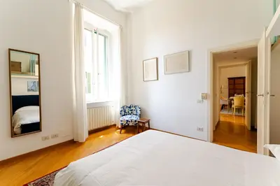 a white bedroom with a bed and a mirror at Trastevere - Dolce Vita 4bedr 360 Terrace in Rome