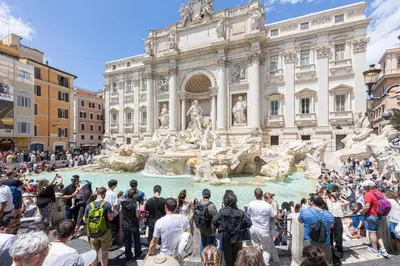 a crowd of people standing around a fountain in front of a building at Luxury Suite Trevi in Rome
