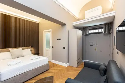 a bedroom with a bed and a chair at Luxury Suite Trevi in Rome