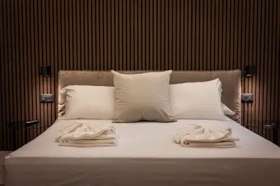 a bed with white pillows and towels on it at Luxury Suite Trevi in Rome