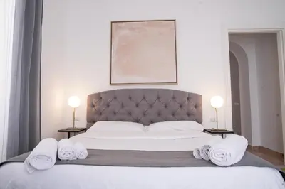 a bedroom with a large bed with towels on it at VILLA LINA - sky earth liberty villa - 5 min from tube in Rome
