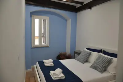 a blue bedroom with a bed and a window at Casa del Giglio in Rome