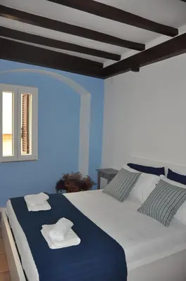 a bedroom with a large white bed with blue walls at Casa del Giglio in Rome