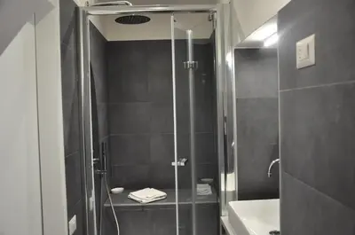 a bathroom with a shower with a glass door at Casa del Giglio in Rome