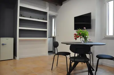 a dining room with a table and chairs and a television at Casa del Giglio in Rome
