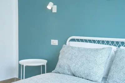 a blue bedroom with a bed and a table at Charming Apartment Gregory in Rome