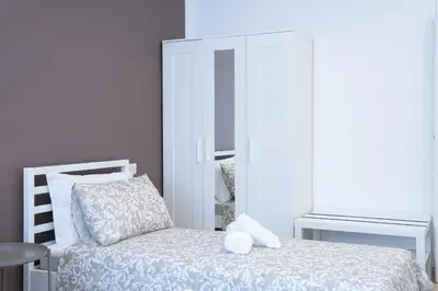 a bedroom with a white bed and a mirror at Charming Apartment Gregory in Rome