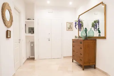 a hallway with a mirror and a dresser with vases on it at Charming Apartment Gregory in Rome