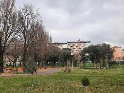 a park with trees and a building in the background at GES House Roma in Rome