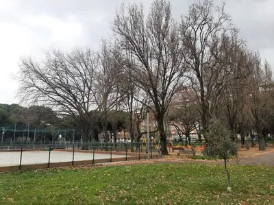 a park with trees and a bench and a fence at GES House Roma in Rome