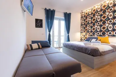 a bedroom with two beds and a couch in it at GES House Roma in Rome