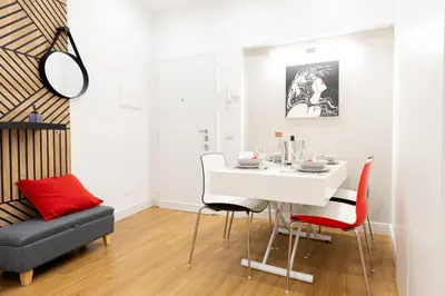 a dining room with a white table and red chairs at GES House Roma in Rome