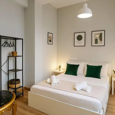 a bedroom with a large white bed with green pillows at Flaminia Design Apartment - GR HOME in Rome