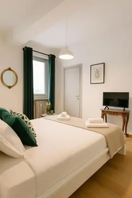 a large white bed in a room with a television at Flaminia Design Apartment - GR HOME in Rome