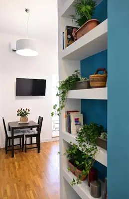 a dining room with a table and shelves with plants at At Home Montebello in Rome