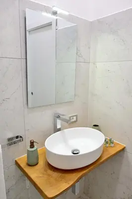 a bathroom with a white sink and a mirror at At Home Montebello in Rome
