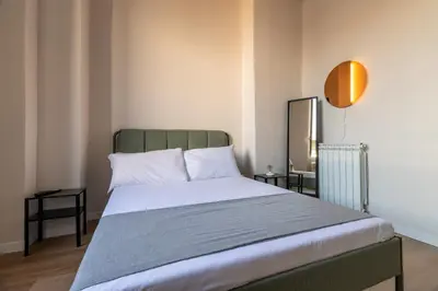a bedroom with a large bed with white sheets at Joe Litty Rooms in Rome