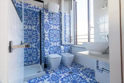 a blue and white bathroom with a toilet and a sink at Joe Litty Rooms in Rome