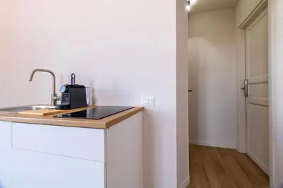 a kitchen with white cabinets and a sink at Joe Litty Rooms in Rome