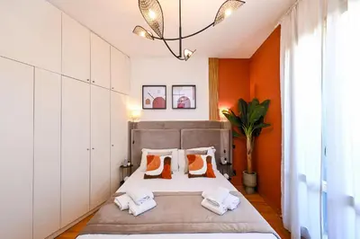 a bedroom with a bed with orange walls at Navona design rooftop in Rome