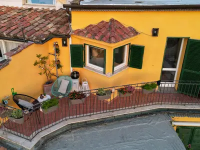 a yellow house with a balcony with plants on it at Navona design rooftop in Rome