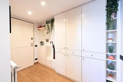 a large white kitchen with white cabinets and wood floors at Navona design rooftop in Rome