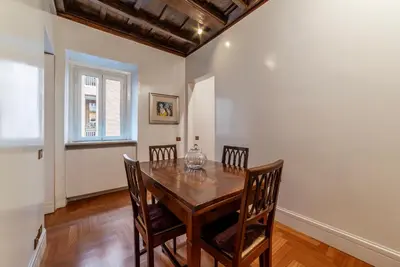 a dining room with a wooden table and chairs at Frezza 39b - FromeHometoRome in Rome