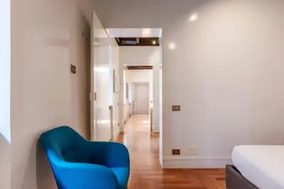 a blue chair in a room with a hallway at Frezza 39b - FromeHometoRome in Rome