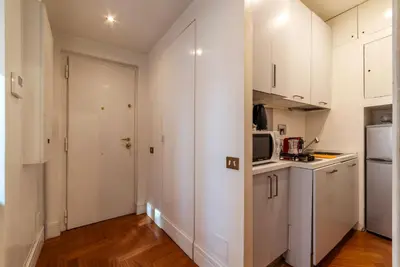 a kitchen with white cabinets and a microwave at Frezza 39b - FromeHometoRome in Rome