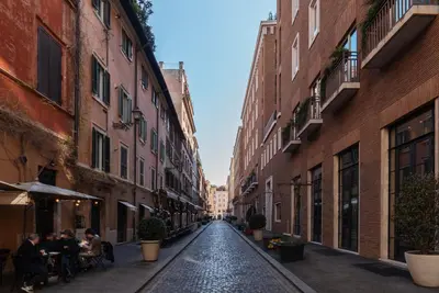 an empty street in an alley between buildings at Frezza 39b - FromeHometoRome in Rome