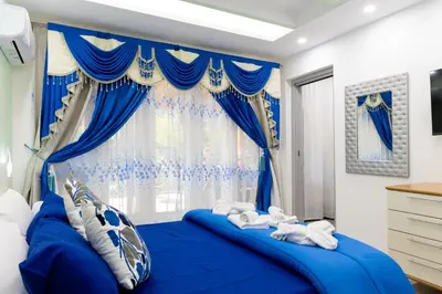 a bedroom with blue curtains and a blue bed at La Dolce Casa in Rome