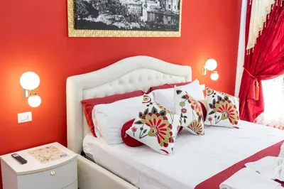 a bedroom with red walls and a white bed with red pillows at La Dolce Casa in Rome