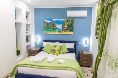 a bedroom with blue walls and a bed with green pillows at La Dolce Casa in Rome