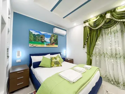 a bedroom with two beds and a blue wall at La Dolce Casa in Rome