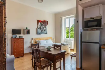 a kitchen and living room with a table and a bed at Sales - FromHometoRome in Rome