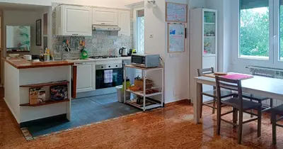 a kitchen with white cabinets and a table and a counter at Vatican Museums Balcony Apartment - Fast Wi-Fi & Metro Nearby in Rome