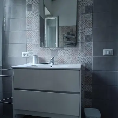 a bathroom with a white sink and a mirror at Vatican Museums Balcony Apartment - Fast Wi-Fi & Metro Nearby in Rome