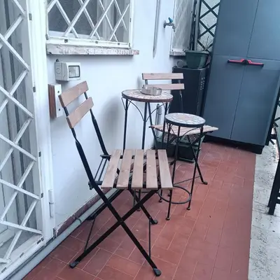 a bench and two tables and chairs on a patio at Vatican Museums Balcony Apartment - Fast Wi-Fi & Metro Nearby in Rome