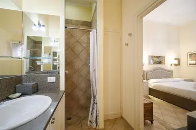 a bathroom with a sink and a shower and a bed at La Casa del Capitano by BuddyRent in Rome