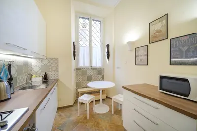 a small kitchen with a sink and a table at La Casa del Capitano by BuddyRent in Rome