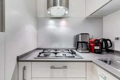 a kitchen with a stove top oven next to a coffee maker at Barberini - FromHometoRome in Rome