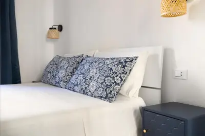 a bed with a blue and white pillow on it at Nextovatican Apartment in Rome