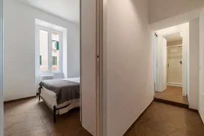 a bedroom with a bed and a hallway with a window at Testaccio - FromHometoRome in Rome