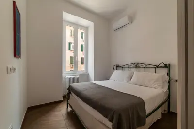 a bed in a white room with a window at Testaccio - FromHometoRome in Rome